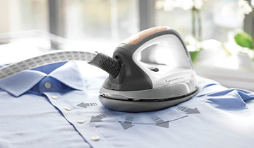 A imagem mostra a parte de tras do ferro Polti Vaporella Next VN18.40 posicionado sobre uma camisa