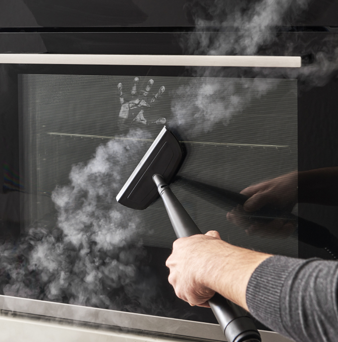 a person cleaning oven mirror