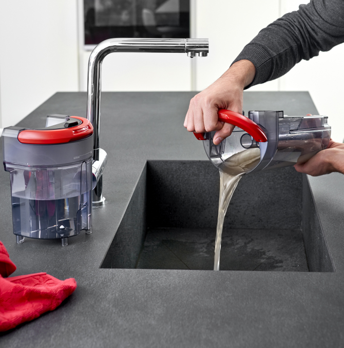 a guy throwing dirty water tank in a sink
