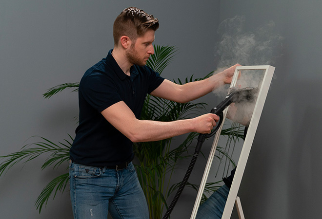 Polti limpando um espelho com vapor